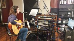 Kyleen Downes during production recording acoustic guitar