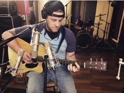 Adam Gingrich recording acoustic guitar during production